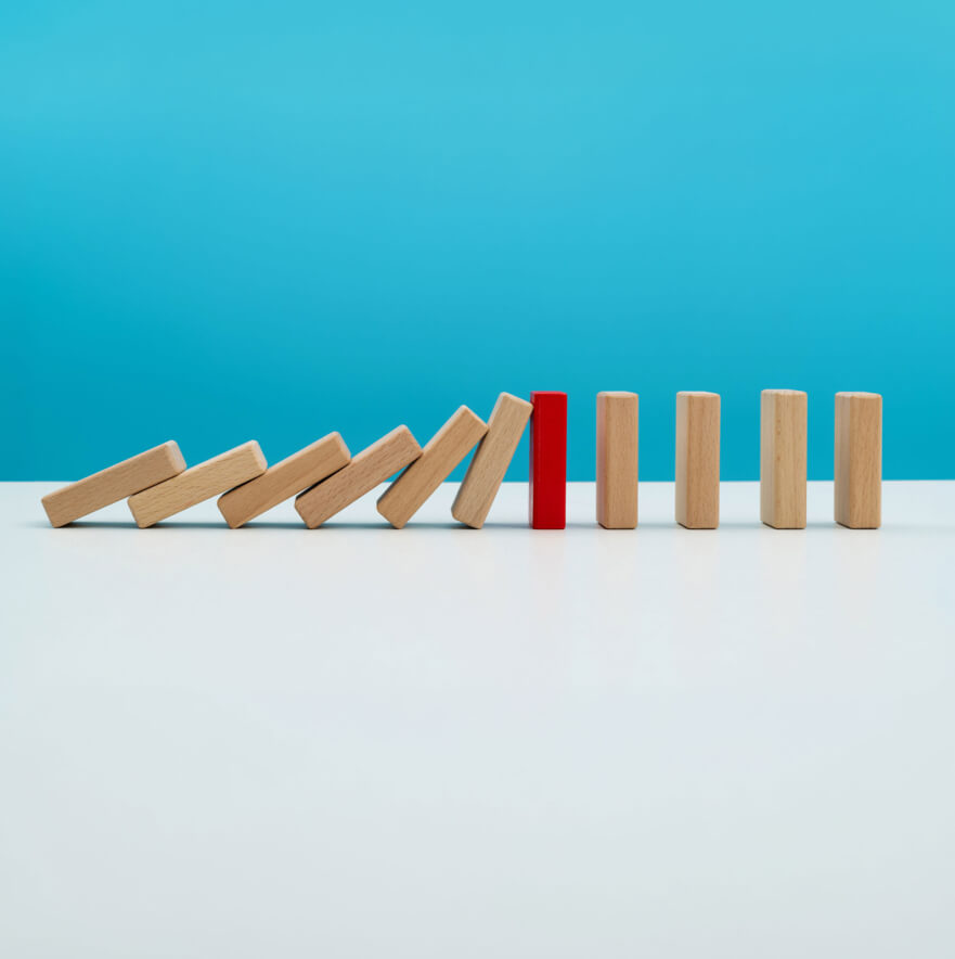Domino in legno con un pezzo rosso in mezzo alla fila