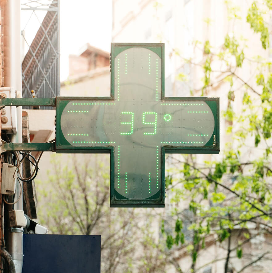 Insegna verde di una farmacia con temperatura di 39°